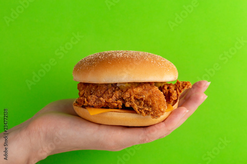Woman's hand is holding delicious hamburger or burger