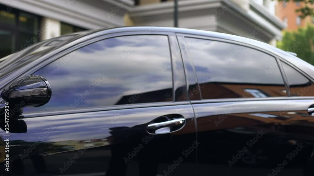 Male in business suit getting out expensive car and locking it, promotion