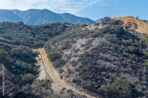 Dirt road cut into forest for construction near mountains