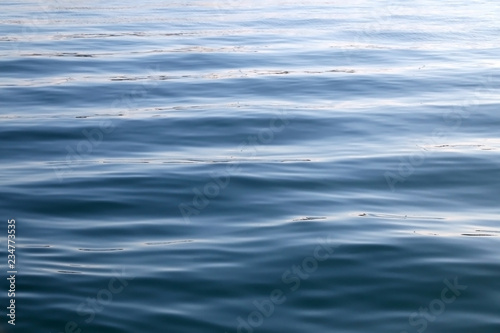Close-up of sea texture with small waves. Selective focus, deep blue color.