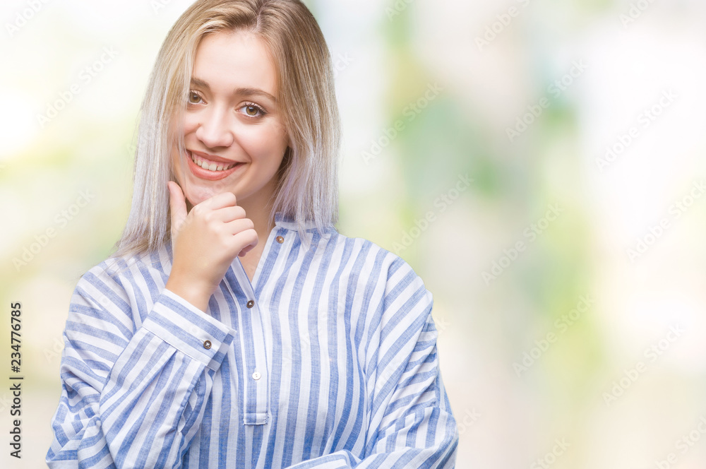 Young blonde woman over isolated background looking confident at the camera with smile with crossed arms and hand raised on chin. Thinking positive.