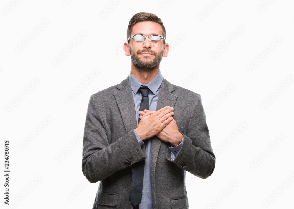 Young handsome business man over isolated background smiling with hands on chest with closed eyes and grateful gesture on face. Health concept.