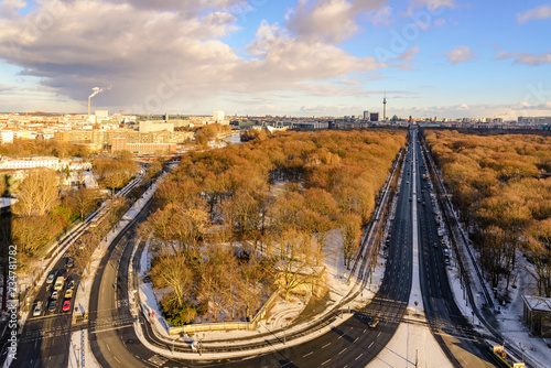 Aerial panoramic view of cityscape of Berlin skyline and scenery of trees without leaves in winter season at Tiergarten park from above at Victory Column with background of dusk sunset sky in Berlin.