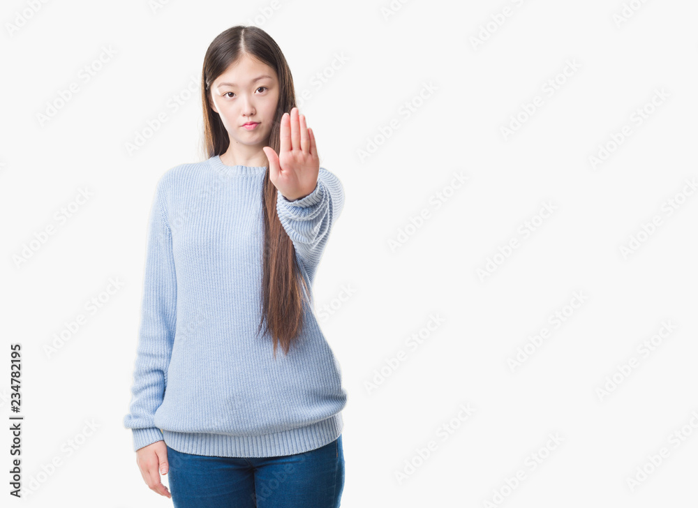 Young Chinese woman over isolated background doing stop sing with palm of the hand. Warning expression with negative and serious gesture on the face.