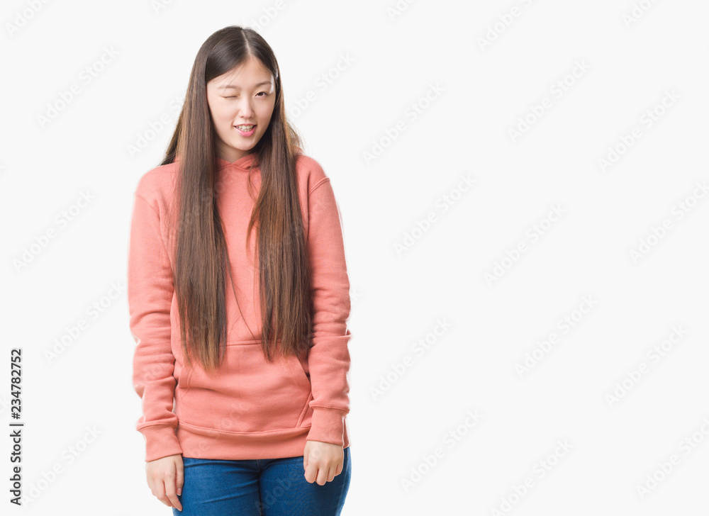 Young Chinese woman over isolated background wearing sport sweathshirt winking looking at the camera with sexy expression, cheerful and happy face. Young Chinese woman over isolated background wearing sport sweathshirt winking looking at the camera with sexy expression, cheerful and happy face.