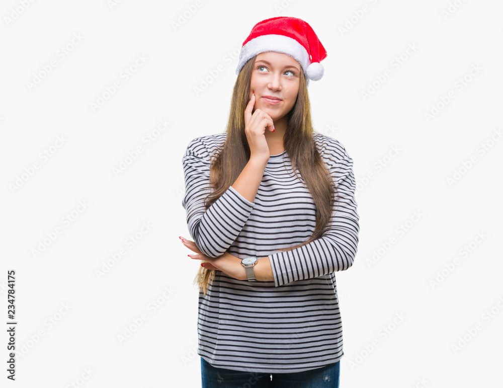 Young beautiful caucasian woman wearing christmas hat over isolated background with hand on chin thinking about question, pensive expression. Smiling with thoughtful face. Doubt concept. Young beautiful caucasian woman wearing christmas hat over isolated background with hand on chin thinking about question, pensive expression. Smiling with thoughtful face. Doubt concept.
