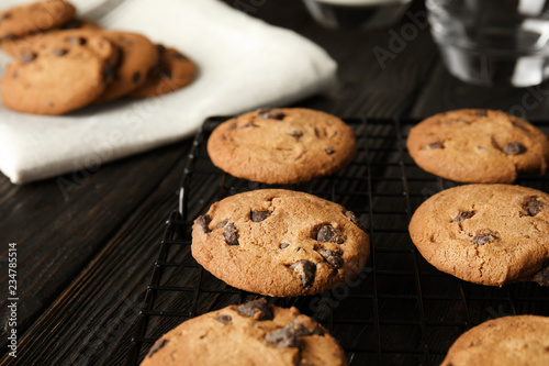 Cooling rack with chocolate chip cookies on wooden background