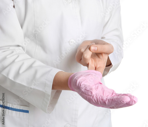 Doctor taking off medical glove on white background