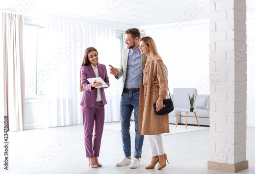 Female real estate agent working with couple in room