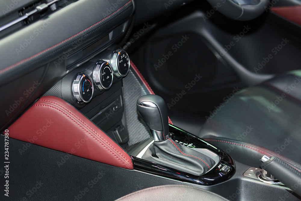 Red luxury car Interior with steering wheel, shift lever and air condition and radio button control in car