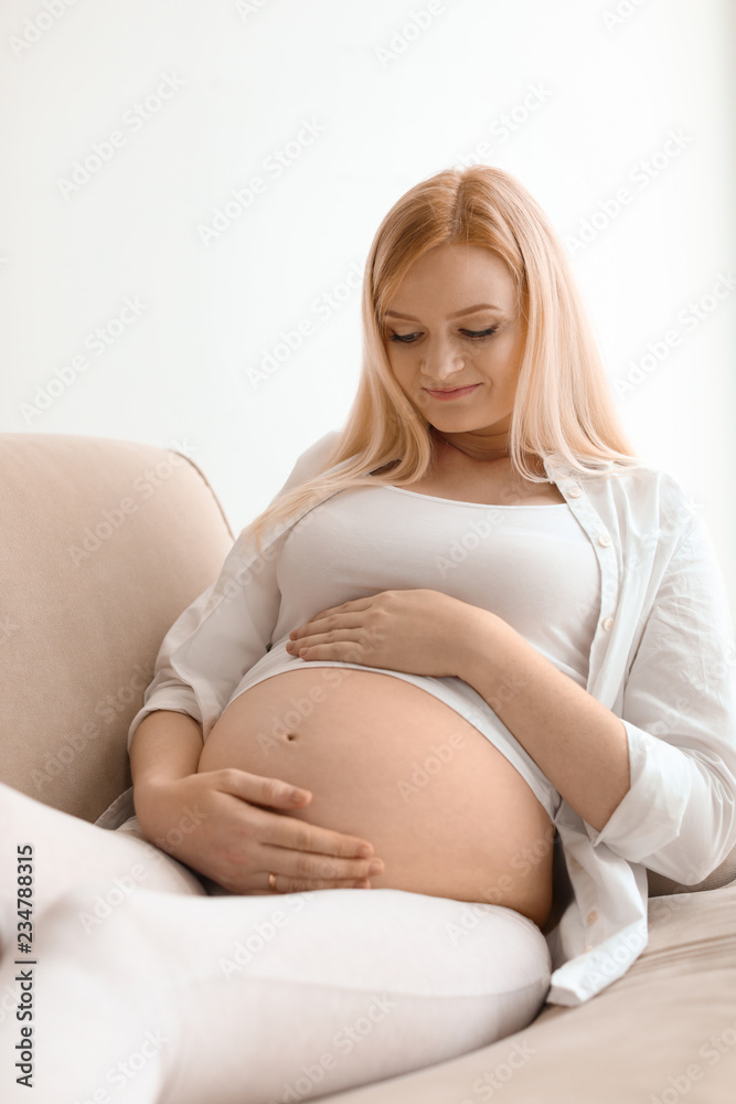 Beautiful pregnant woman resting on sofa at home Beautiful pregnant woman resting on sofa at home