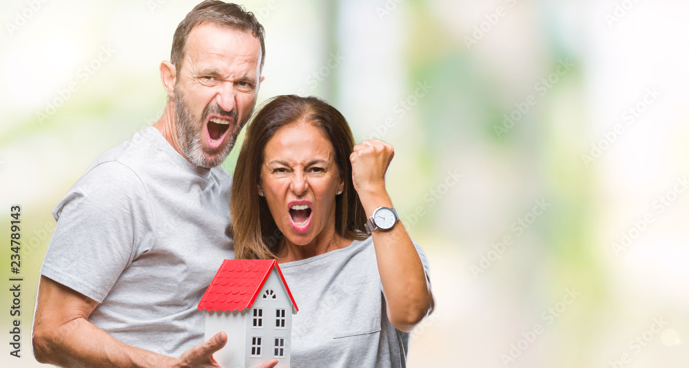 Middle age hispanic casual couple buying new house over isolated background annoyed and frustrated shouting with anger, crazy and yelling with raised hand, anger concept Middle age hispanic casual couple buying new house over isolated background annoyed and frustrated shouting with anger, crazy and yelling with raised hand, anger concept