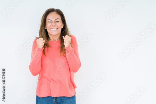 Beautiful middle age woman over isolated background excited for success with arms raised celebrating victory smiling. Winner concept. © Krakenimages.com