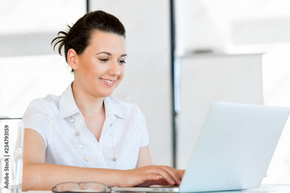 Portrait of businesswoman working at computer in office Portrait of businesswoman working at computer in office