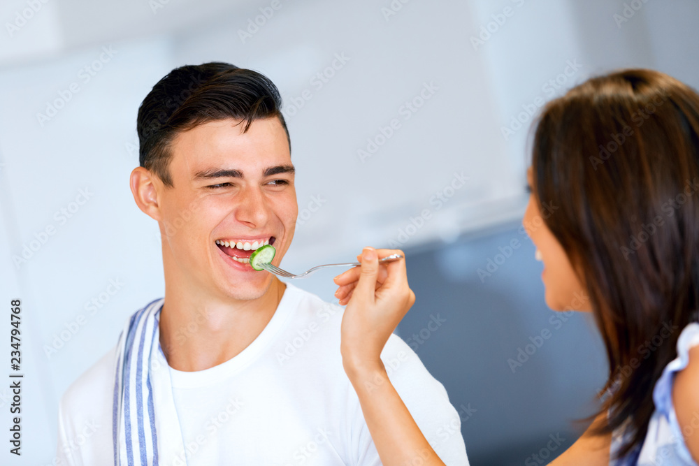 Couple cooking and tasting food