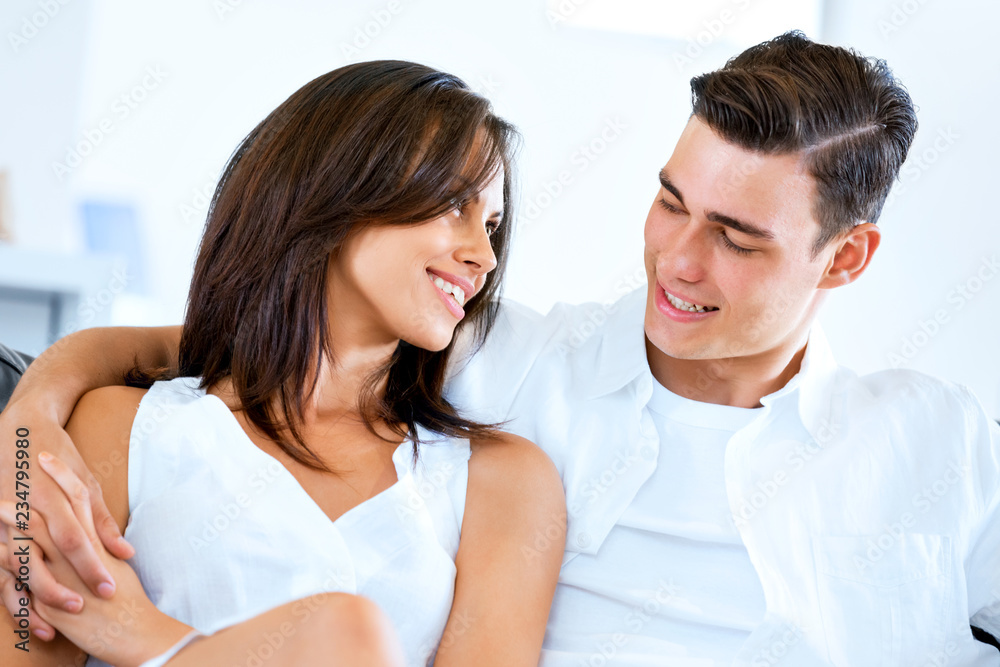 Young couple looking at camera while sitting at home Young couple looking at camera while sitting at home