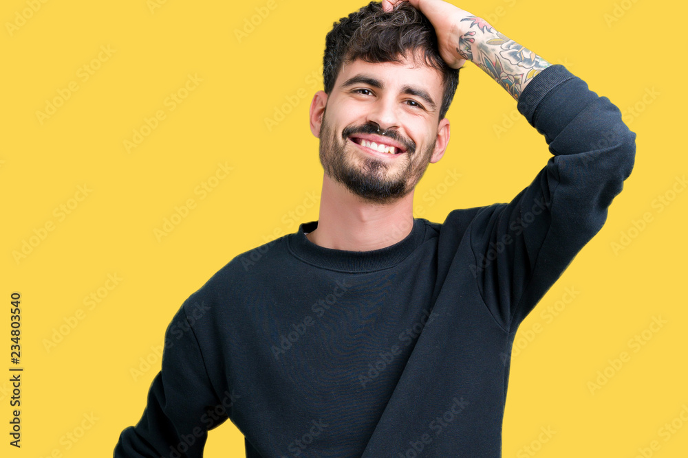 Young handsome man over isolated background Smiling confident touching hair with hand up gesture, posing attractive Young handsome man over isolated background Smiling confident touching hair with hand up gesture, posing attractive
