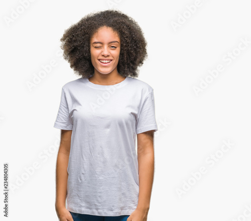 Young afro american woman over isolated background winking looking at the camera with sexy expression, cheerful and happy face.
