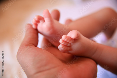 Father holding baby feet © Aleksandar