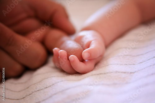 baby holding father's finger