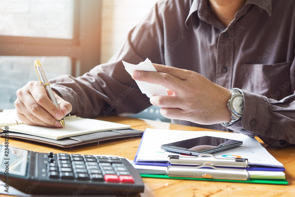 Business and finance concept of office working, Businessman using calculator to calculate bill payment Business and finance concept of office working, Businessman using calculator to calculate bill payment