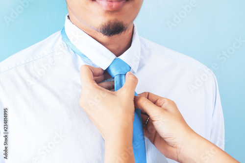 Wife tying necktie of her husband, Close up shot, Asian man with beard