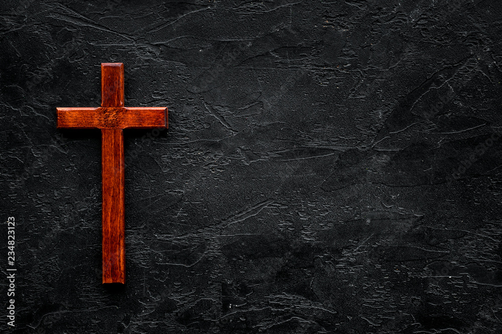 Funeral concept. Wooden cross on black background top view copy space