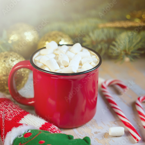 Christmas. Christmas background. Happy New Year. Holiday Red mug with hot chocolate white marshmallows and candy in the shape of a Christmas tree. Selective focus.