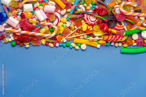 Colorful candies on table on blue background
