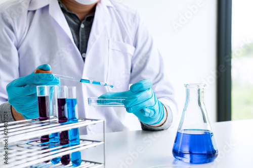 Biochemistry laboratory research, Chemist is analyzing sample in laboratory with equipment and science experiments glassware containing chemical liquid