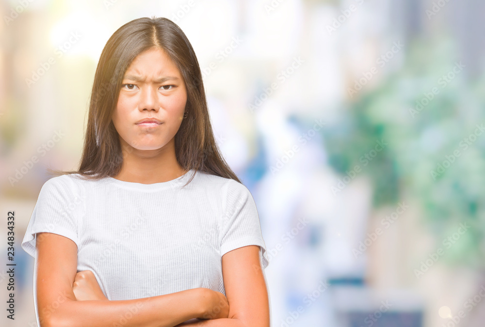 Young asian woman over isolated background skeptic and nervous, disapproving expression on face with crossed arms. Negative person. Young asian woman over isolated background skeptic and nervous, disapproving expression on face with crossed arms. Negative person.