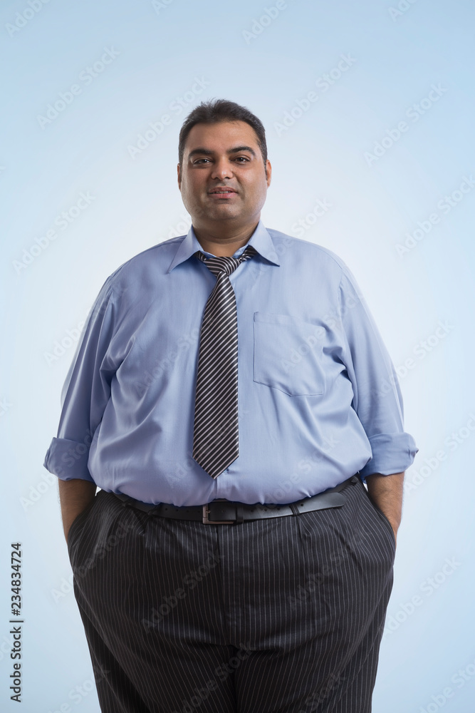 Portrait of obese man in formal clothes standing with hands in pocket Portrait of obese man in formal clothes standing with hands in pocket