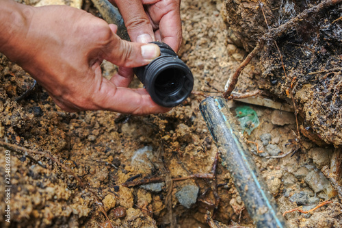 Wallpaper Mural Sawing or cutting leaking poly pipe or HDPE using hacksaw blade Torontodigital.ca