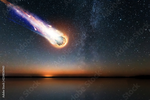 A comet, an asteroid, a meteorite falls to the ground against a starry sky. Attack of the meteorite. Meteor Rain. Kameta tail. End of the world. Astranomy.