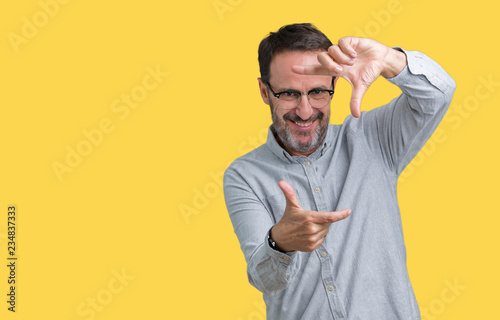 Handsome middle age elegant senior man wearing glasses over isolated background smiling making frame with hands and fingers with happy face. Creativity and photography concept.