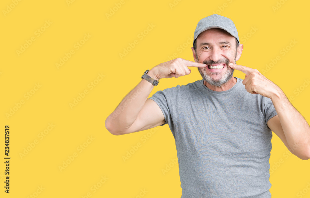 Handsome middle age hoary senior man wearing sport cap over isolated background smiling confident showing and pointing with fingers teeth and mouth. Health concept. Handsome middle age hoary senior man wearing sport cap over isolated background smiling confident showing and pointing with fingers teeth and mouth. Health concept.