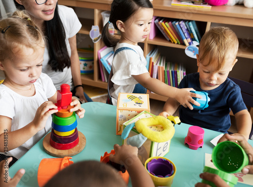 Nursery children playing with teacher in the classroom