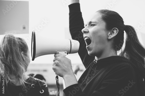 Fototapeta Female activist shouting on a megaphone