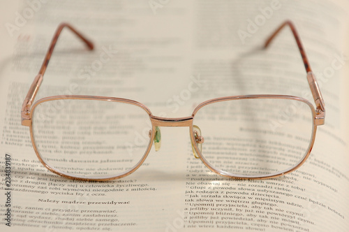 Eyeglasses lying on an old book