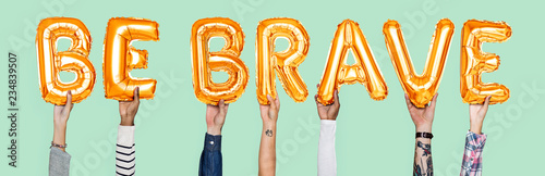 Photo Hands holding Be Brave word in balloon letters