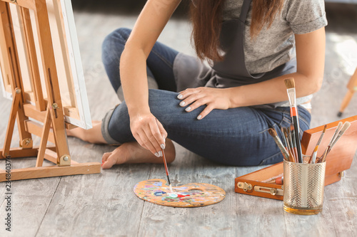 Female artist painting picture in workshop