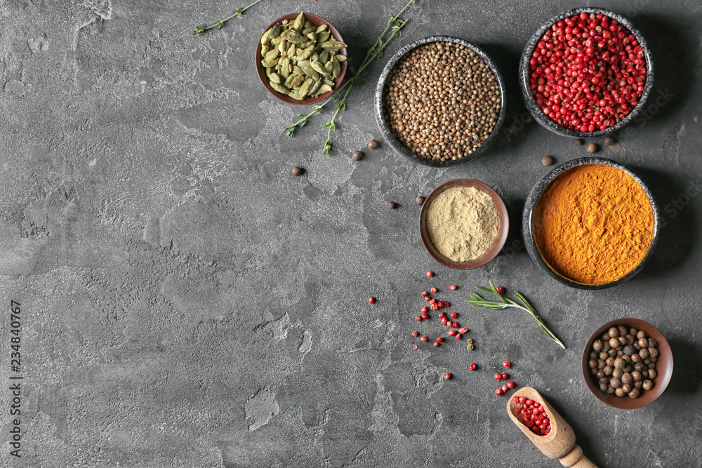 Bowls with different aromatic spices on grey background Bowls with different aromatic spices on grey background