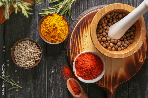 Fototapeta Naklejka Na Ścianę i Meble -  Bowls and mortar with different aromatic spices on wooden table