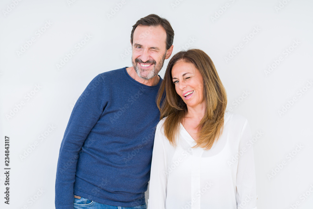 Beautiful middle age couple in love over isolated background winking looking at the camera with sexy expression, cheerful and happy face. Beautiful middle age couple in love over isolated background winking looking at the camera with sexy expression, cheerful and happy face.