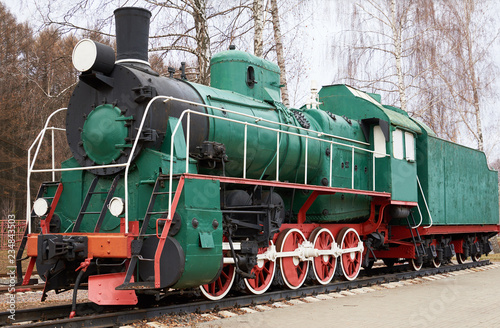 Side view of classic old green steam locomotive on rail tracks