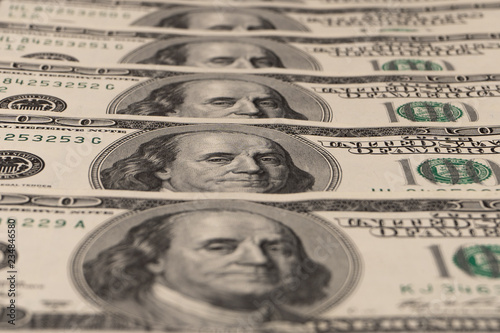 Close-up. Fan of hundred dollar bills in the center of a black background