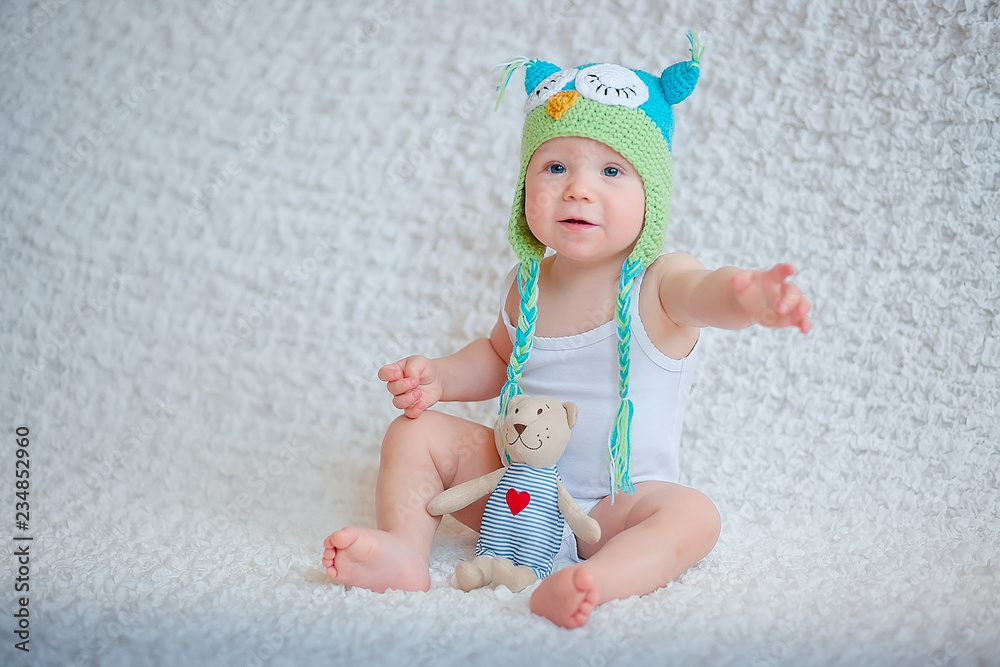 A child in a funny hat asks for a toy A child in a funny hat asks for a toy