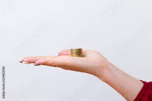 Closeup of a woman's hand holding a stack of kazakhstani 100 tenge coins. Saving and spending concept