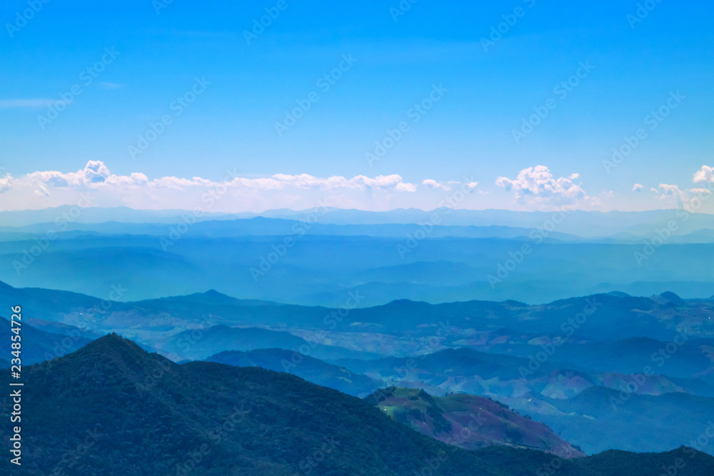 The mountains and forests with blue sky and white clouds at the peak of Inthanon national park (park name) in Chiang Mai province , Thailand in a sunny day. 