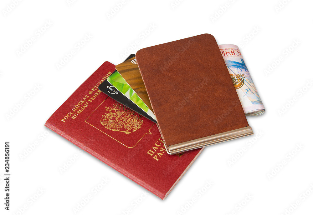 Desk of frequent traveler - angle view. The composition of essential items for trip: passport with multiple entry stamps, foreign cash notes, wallet with credit cards. Desk of frequent traveler - angle view. The composition of essential items for trip: passport with multiple entry stamps, foreign cash notes, wallet with credit cards.